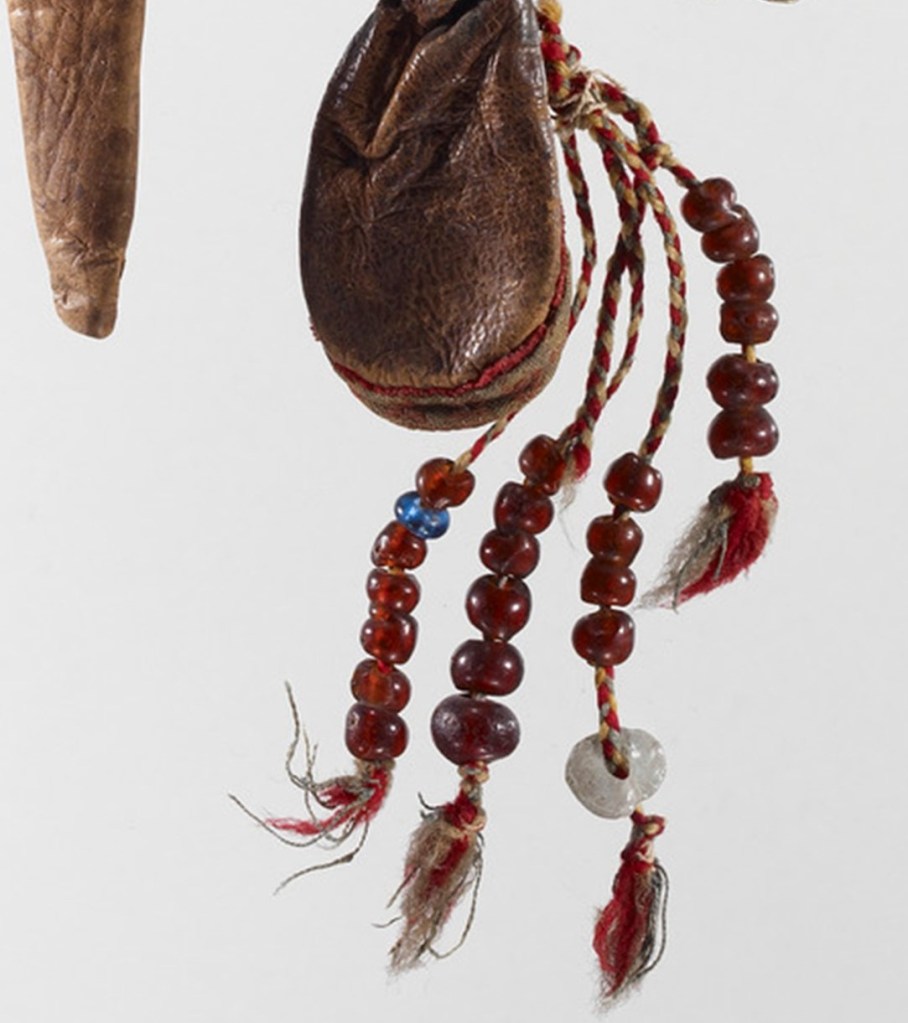 Yksityiskohta vyöllisistä, jossa näkyy koristeena lasihelmiä.