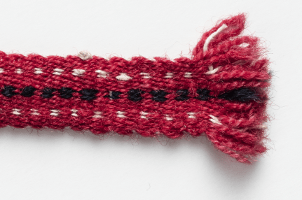 Alkuperäinen seiskarilainen sukkanauha, yksityiskohta nauhan päästä.