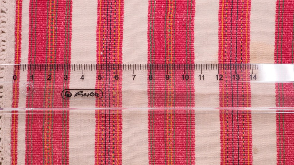 Lähikuva ruokolahtelaisen esiliinan kudonnaisraidoista.