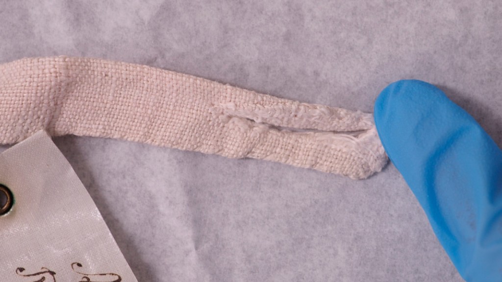 Solmimisnauhan kiinnityslenkki ruokolahtelaisessa esiliinassa.