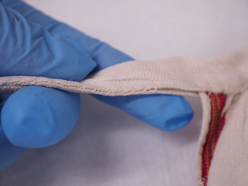 Vyötärökaitaleen pään ompeleet ruokolahtelaisessa esiliinassa.