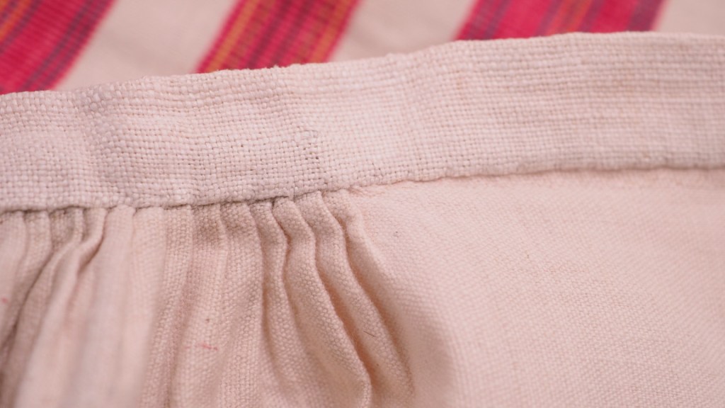 Vyötärön laskoksia ruokolahtelaisessa esiliinassa.