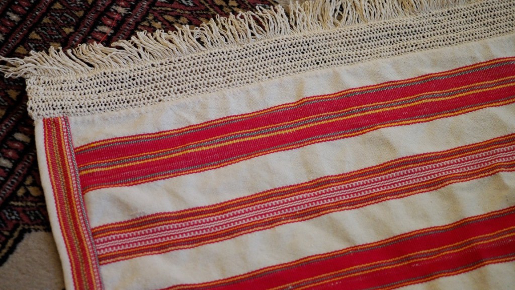 Jääsken tyyliin tehdyn esiliinan helmapitsi ja hapsut.