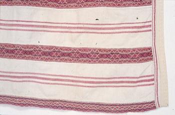 Lähikuva Jääsken kihlakunann esiliinasta, jossa nyytingit ovat punaisia .