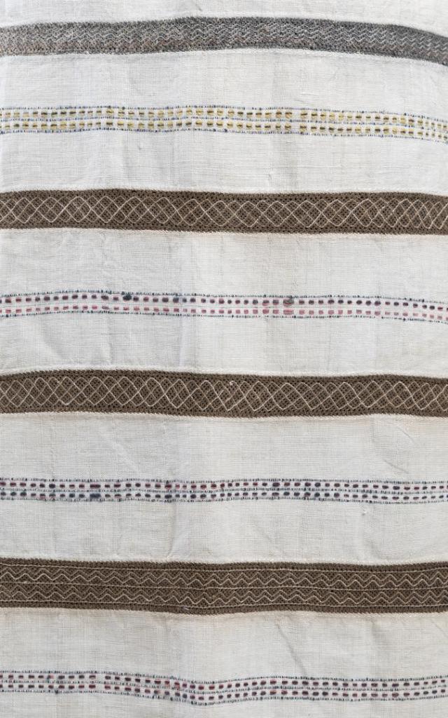 Lähikuva Jääsken kihlakunann esiliinasta, jossa nyytingit ovat ruskeita ja harmaita.