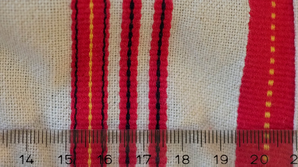Jääsken kihlakunnan kudonnaisesiliinan ripsiraitoja lähikuvassa.