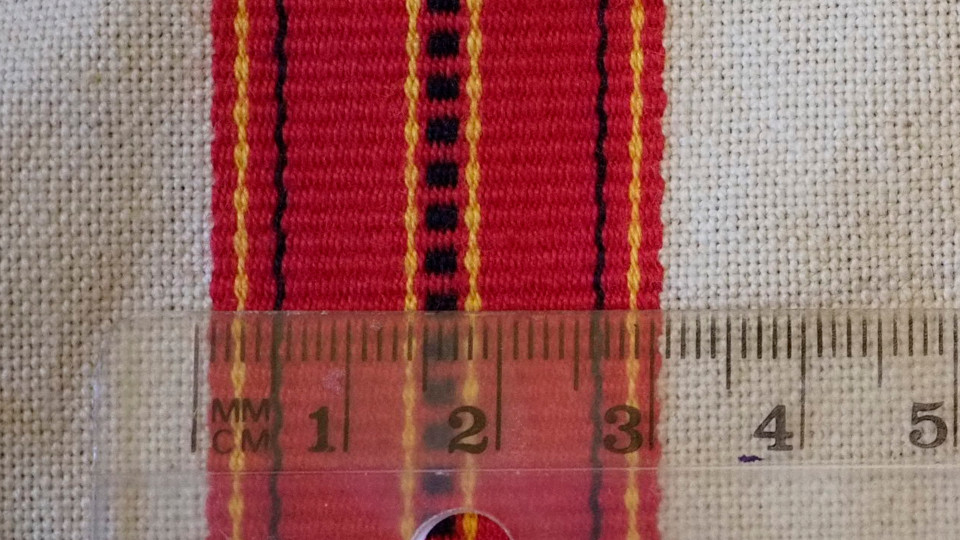 Jääsken kihlakunnan kudonnaisesiliinan ripsiraitoja lähikuvassa.