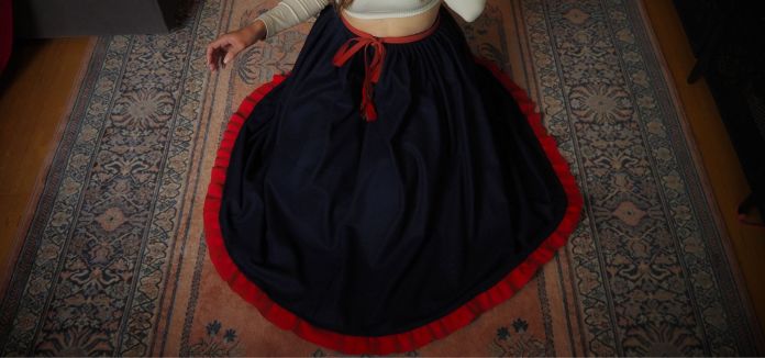 Punaverkainen sininen kansanpuvun hame kuvattuna mallin päällä ylhäältä päin.