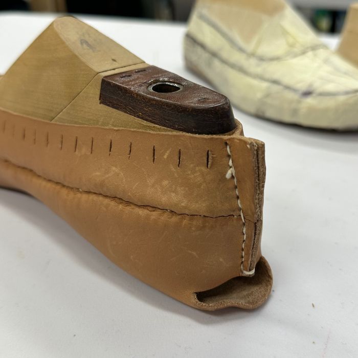 Kengän kannan ompelu.