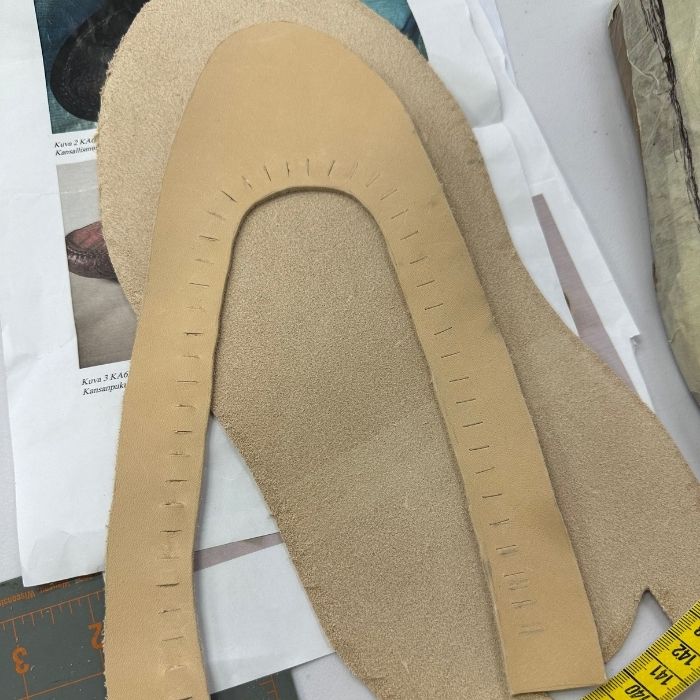 Nahasta leikatut kengän päällis- ja pohjakappaleet.